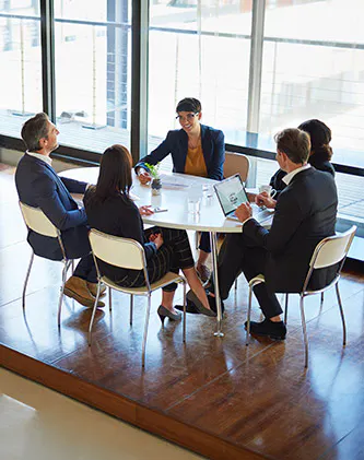 people in a boardroom around a table