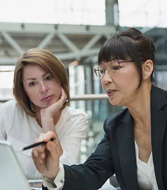 two women reviewing information on a laptop screen